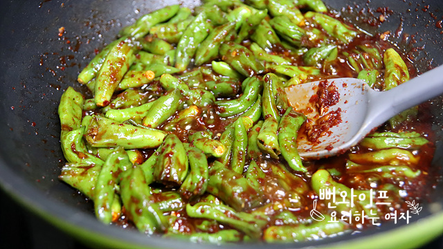 Simmer the shishito peppers in seasoning — step photo