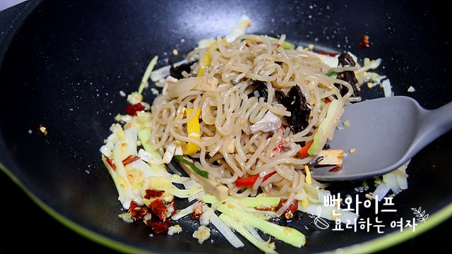 Add the japchae and stir-fry — step photo 1