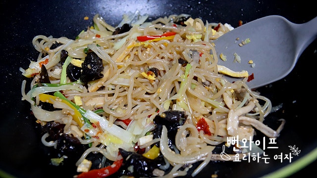 Add the japchae and stir-fry — step photo 2