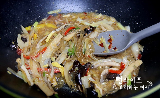 Add the japchae and stir-fry — step photo 2